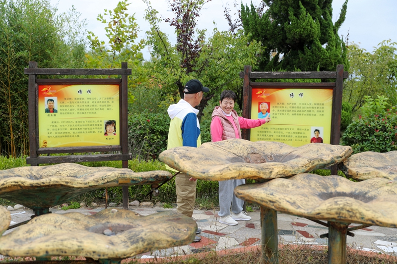 10月7日，在山東省青島市即墨區(qū)溫泉街道錢谷村，游客在交流優(yōu)秀村民的事跡。